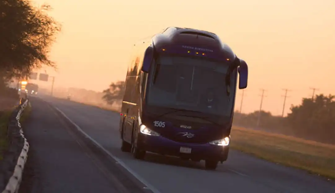 Autobús grupo Senda en carretera al atardecer
